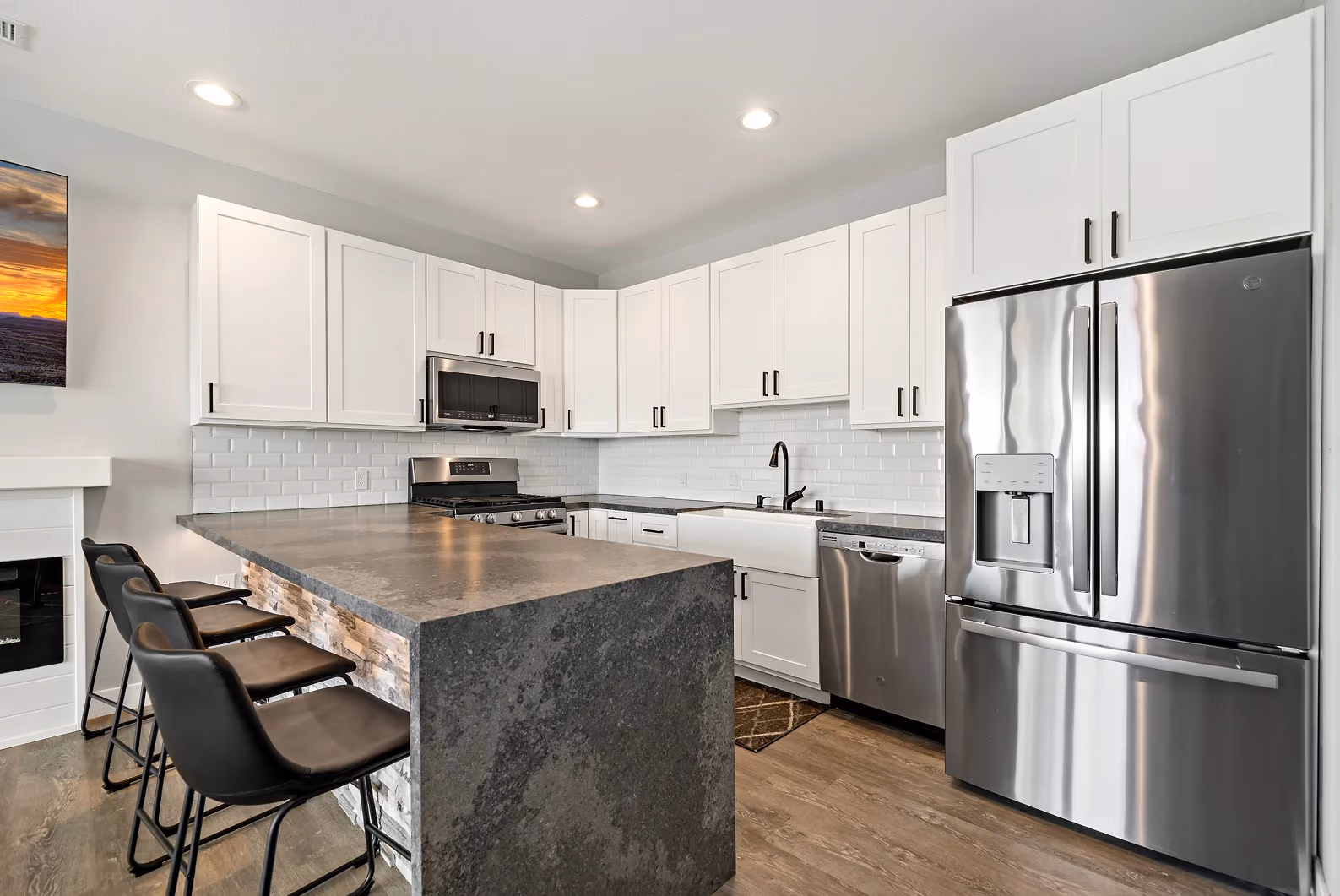 Modern ADU kitchen with white cabinets, dark countertops, and stainless steel appliances